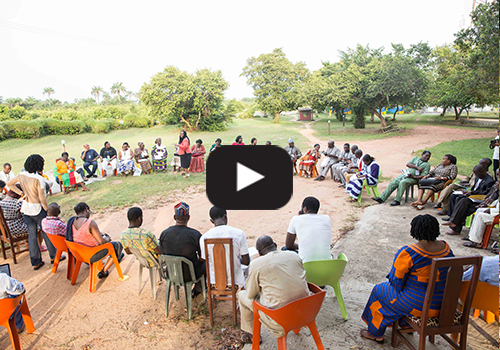 Large circle of Nigerians having a meeting outdoors